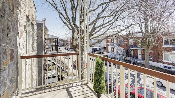 A balcony with a view of a city street, a stone building, and a tree. - Private bathroom with Large Balcony in Montréal close St. Lawrence River (Montréal)