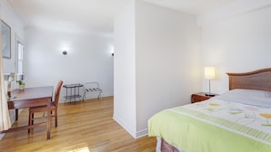 A bedroom with a bed, bedside table, lamp, and a desk with chairs. - Private bathroom with Large Balcony in Montréal close St. Lawrence River (Montréal)