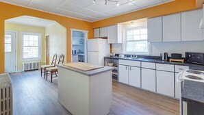 A kitchen with white cabinets, a central island, and a dining area with chairs. - Private bathroom with Large Balcony in Montréal close St. Lawrence River (Montréal)