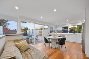 A modern kitchen with a dining area, large windows, and a sliding glass door leading to a patio. - Wray House – Spacious Modern Fremantle Stay (Fremantle)