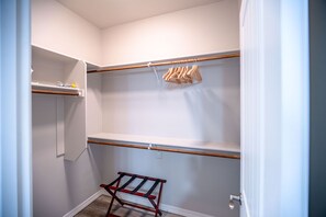 A walk-in closet with wooden shelves and a metal rack. - The Mohave Modern: a 3bed/2bath Cozy, Central Desert Retreat (Kingman)
