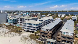 A coastal hotel with multiple buildings, a swimming pool, and a view of the ocean. - Beachfront 2BR Condo with Pool and Beach Access (Gulf Shores)
