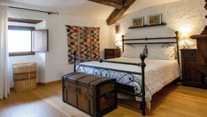 A bedroom with a four-poster bed, a wooden chest, a patterned tapestry, and a rustic ceiling. - Apartment Torre by Interhome (Palazzuolo Sul Senio)