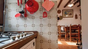 A kitchen with a gas stove, hanging utensils, and a patterned backsplash. - Apartment Torre by Interhome (Palazzuolo Sul Senio)