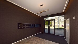 En modern entréhall med ett marmorgolv, en takfläkt och ett bagagehylla som är monterad på väggen.