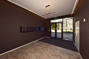 A modern lobby with a marble floor, a ceiling fan, and a wall-mounted luggage rack. - Stylish Manchester Street City Stay (Christchurch)