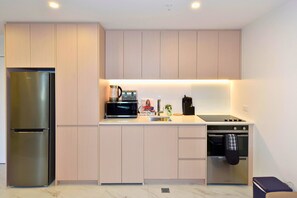A modern kitchen with a stainless steel refrigerator, a microwave, a coffee maker, and a dishwasher. - Stylish Manchester Street City Stay (Christchurch)