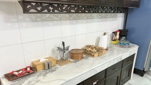 A kitchen with a marble countertop, wooden cabinets, and a decorative metal shelf. - Modern 2BR in Elite DOHS Baridhara – Secure, Quiet & Stylish (Dhaka)