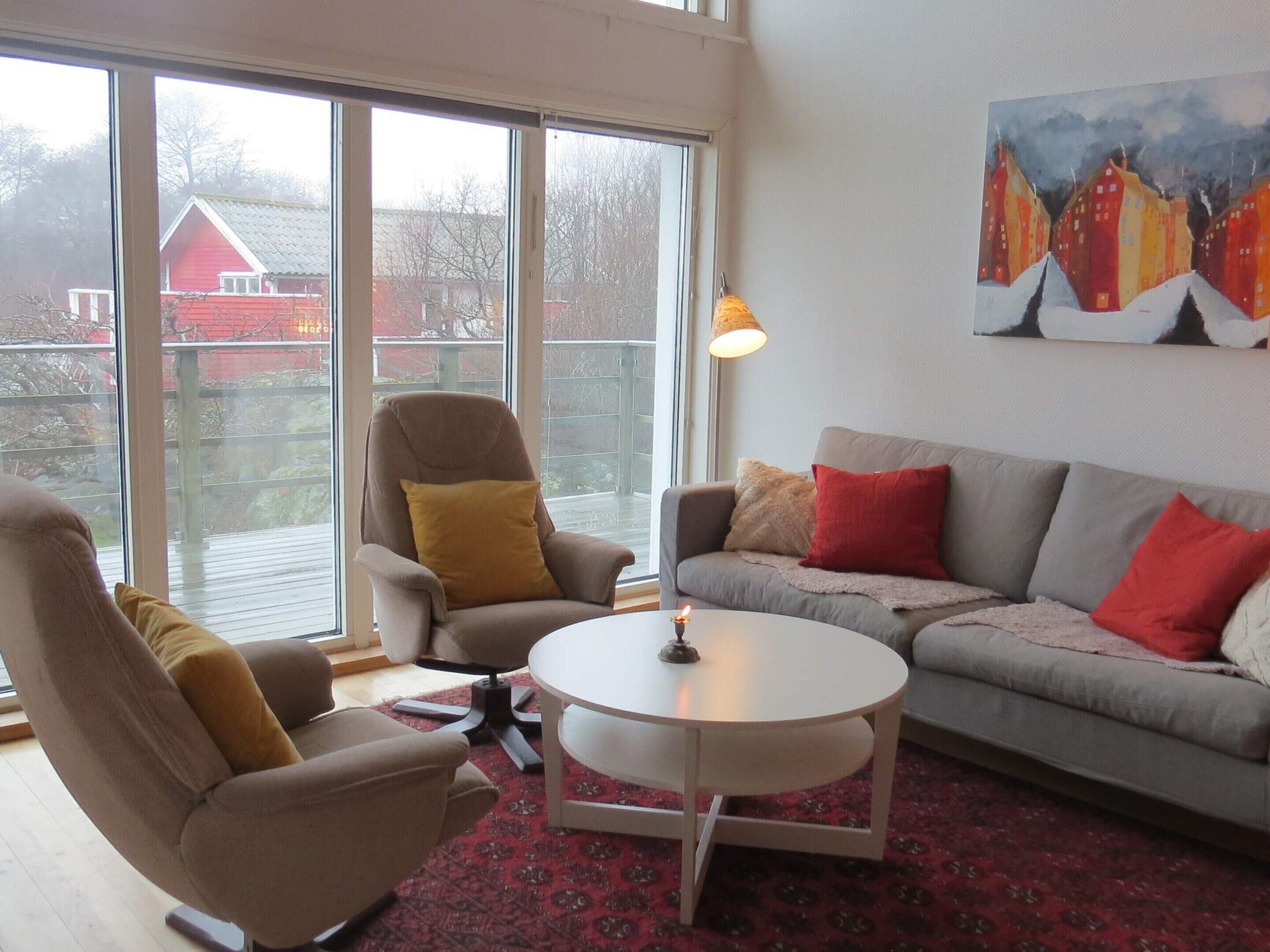 Ein Wohnzimmer mit Sofa, Sesseln, Couchtisch und einem Bild an der Wand.