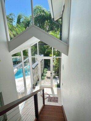 Eine Treppe führt zu einem Poolbereich mit Blick ins Freie.