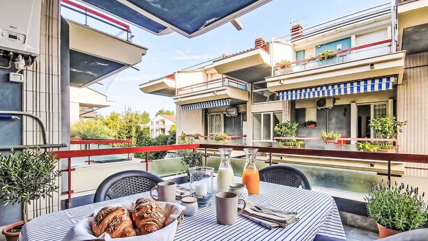 An outdoor dining area with a table set for two, a basket of bread, and a view of the cityscape. - Terrazza Silvi Marina by Interhome (Silvi Marina)