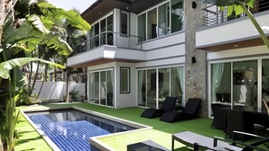 A modern house with a swimming pool, outdoor seating, and large windows. - 3-bedroom Pool Villa in lovely Tambon Kamala with cool AC (Tambon Kamala)