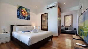 A modern bedroom with a bed, bedside table, and artwork. - 3-bedroom Pool Villa in lovely Tambon Kamala with cool AC (Tambon Kamala)