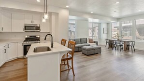 A modern kitchen with white cabinets, a built-in microwave, and a stainless steel sink. - Foothill Flat | Brand New | Garage | Near Ski Canyons (Sandy)