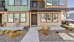 A two-story residential building with a balcony, large windows, and a gravel driveway. - Foothill Flat | Brand New | Garage | Near Ski Canyons (Sandy)