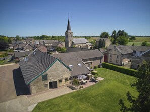 A residential area with a church, houses, and a well-maintained lawn. - Charming cottage in the hilly landscape of South Limburg. (Scheulder)