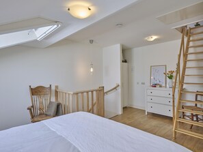 A bedroom with a bed, wooden chair, dresser, and a wooden ladder. - Charming cottage in the hilly landscape of South Limburg. (Scheulder)