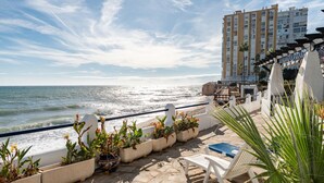 A seaside patio with stone flooring, potted plants, a pool table, and a view of the ocean. - Modern Holiday Home by Beach in Calahonda (Mijas)