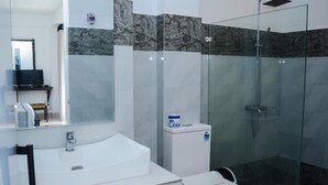 A bathroom with a glass-enclosed shower, a sink, and a toilet. - 49 Ella (Ella)