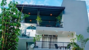 A modern building with a flat roof, multiple balconies, and a sign indicating the address '49 ELLA'. - 49 Ella (Ella)
