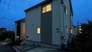 Un bâtiment à deux étages, doté d’un toit plat, d’un petit porche et d’une entrée bien visible.