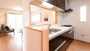 Une cuisine moderne dotée d’une cuisinière encastrée, d’un évier et d’un miroir au-dessus du plan de travail.