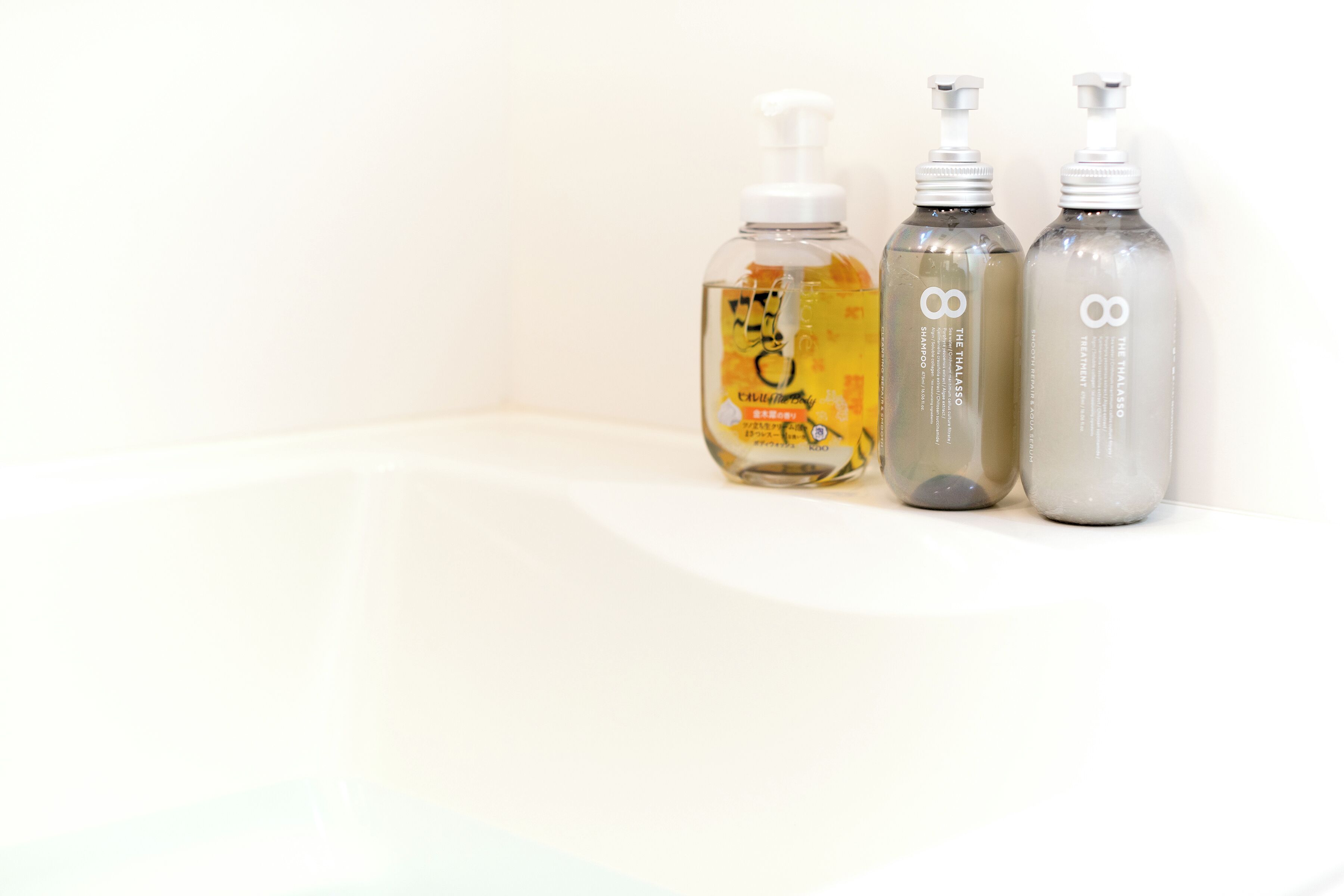 Three bottles of liquid on a white surface.