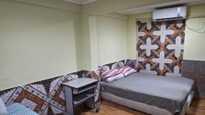 Ein Zimmer mit einem Bett, einem Schreibtisch und einer Klimaanlage.
