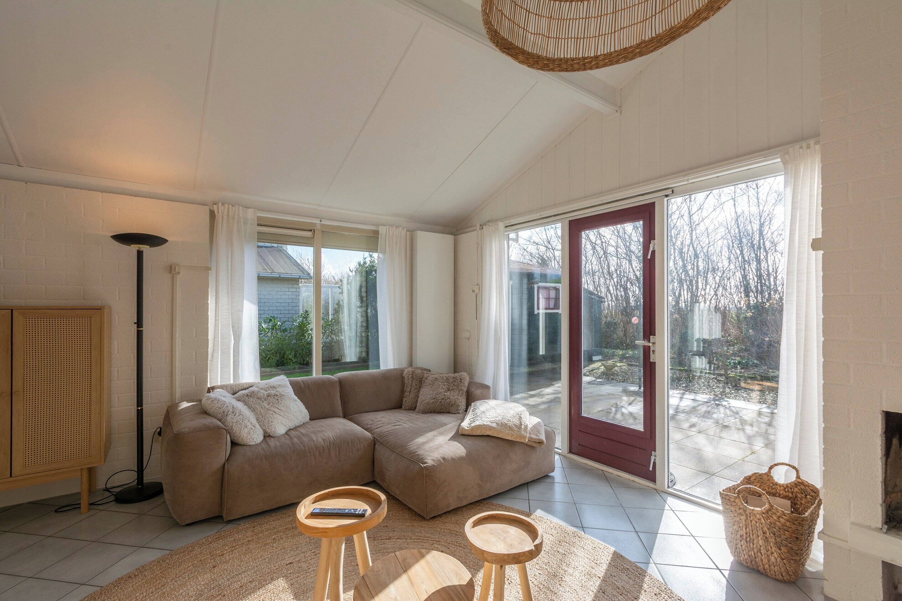 A spacious living room with a large sectional sofa, a floor lamp, and a fireplace.