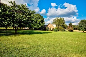 A grassy area with a house in the background. - Clarksville's Château Retreat (Clarksville)