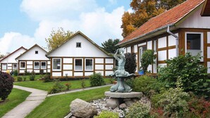 Um edifício tradicional com jardim, uma estátua e um caminho.