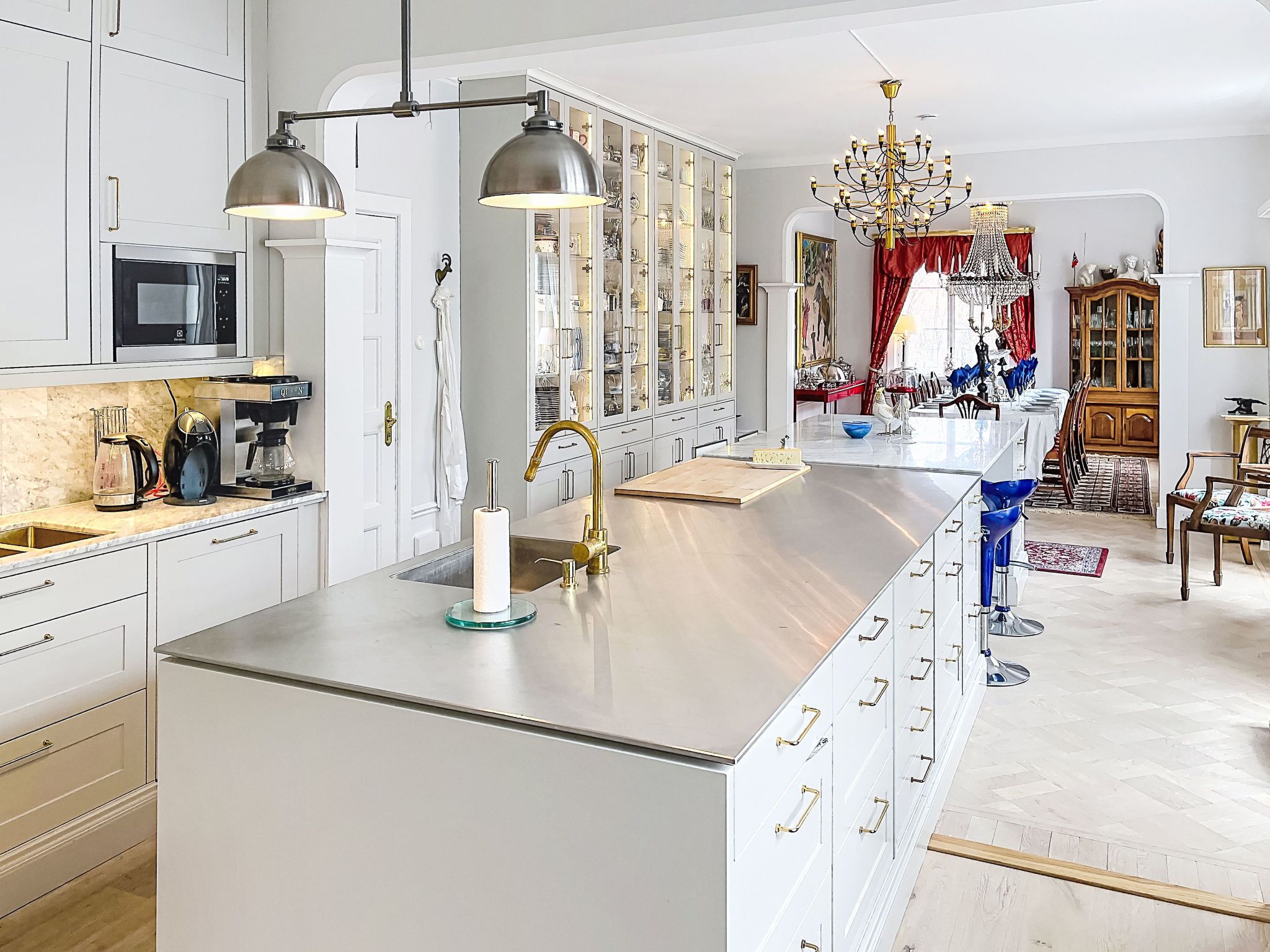 Una cocina moderna con armarios blancos, electrodomésticos de acero inoxidable y una isla central.