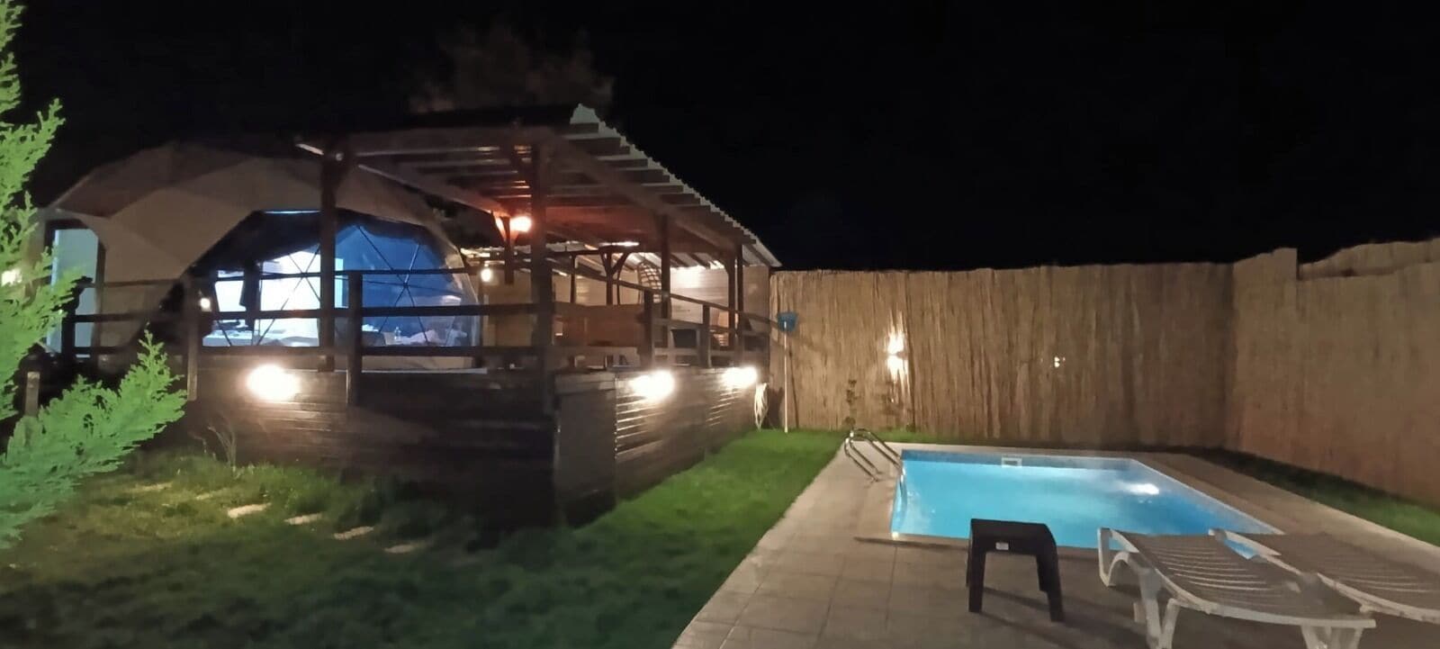 Una cabaña de madera con piscina y zona de estar al aire libre.