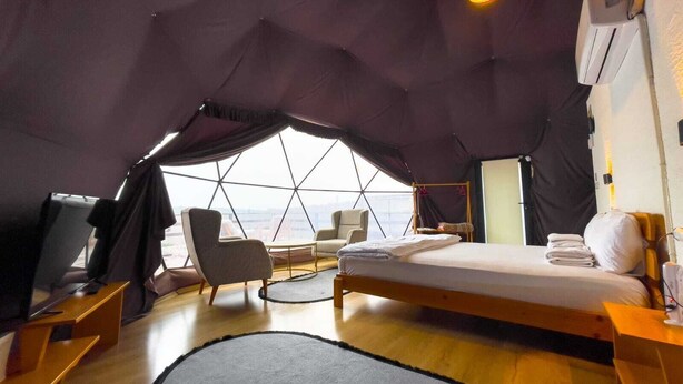 A tented accommodation with a bed, seating area, and a view of the cityscape. - new dome house (Sapanca)
