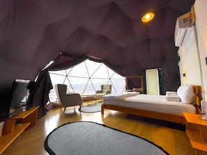 A tented accommodation with a bed, seating area, and a view of the cityscape. - new dome house (Sapanca)