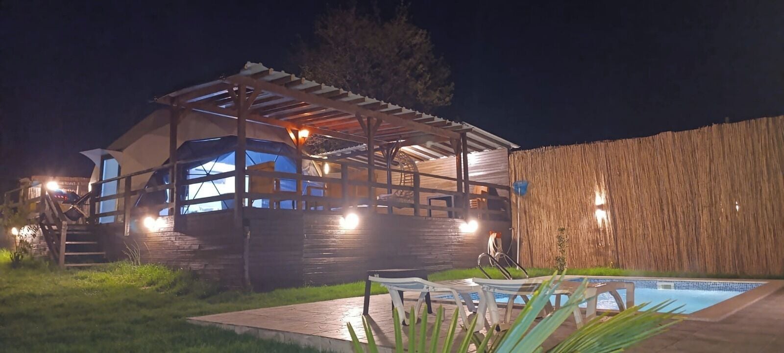 Une maison en bois avec un porche abrité et une piscine.