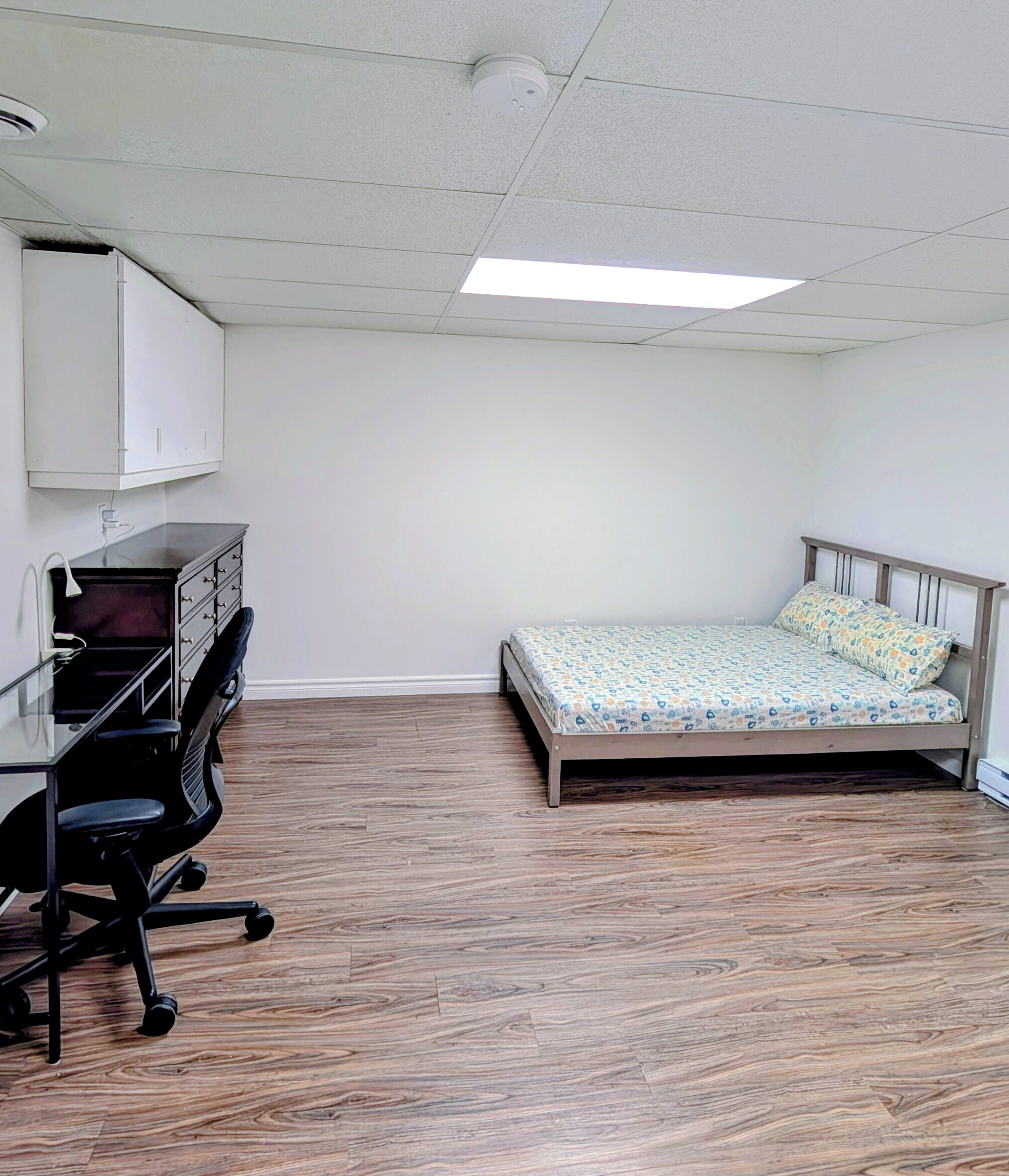 Un dormitorio con cama, escritorio, silla y armario.