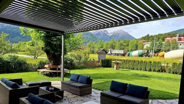 Un patio exterior con mobiliario de mimbre y vistas a las montañas.
