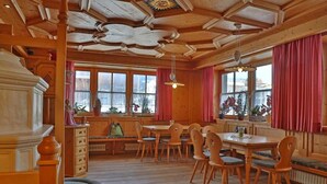 Un interior de madera con comedor, bancos y una chimenea.