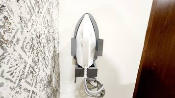A wall-mounted object with a coiled cable, a metal frame, and a white plastic component.