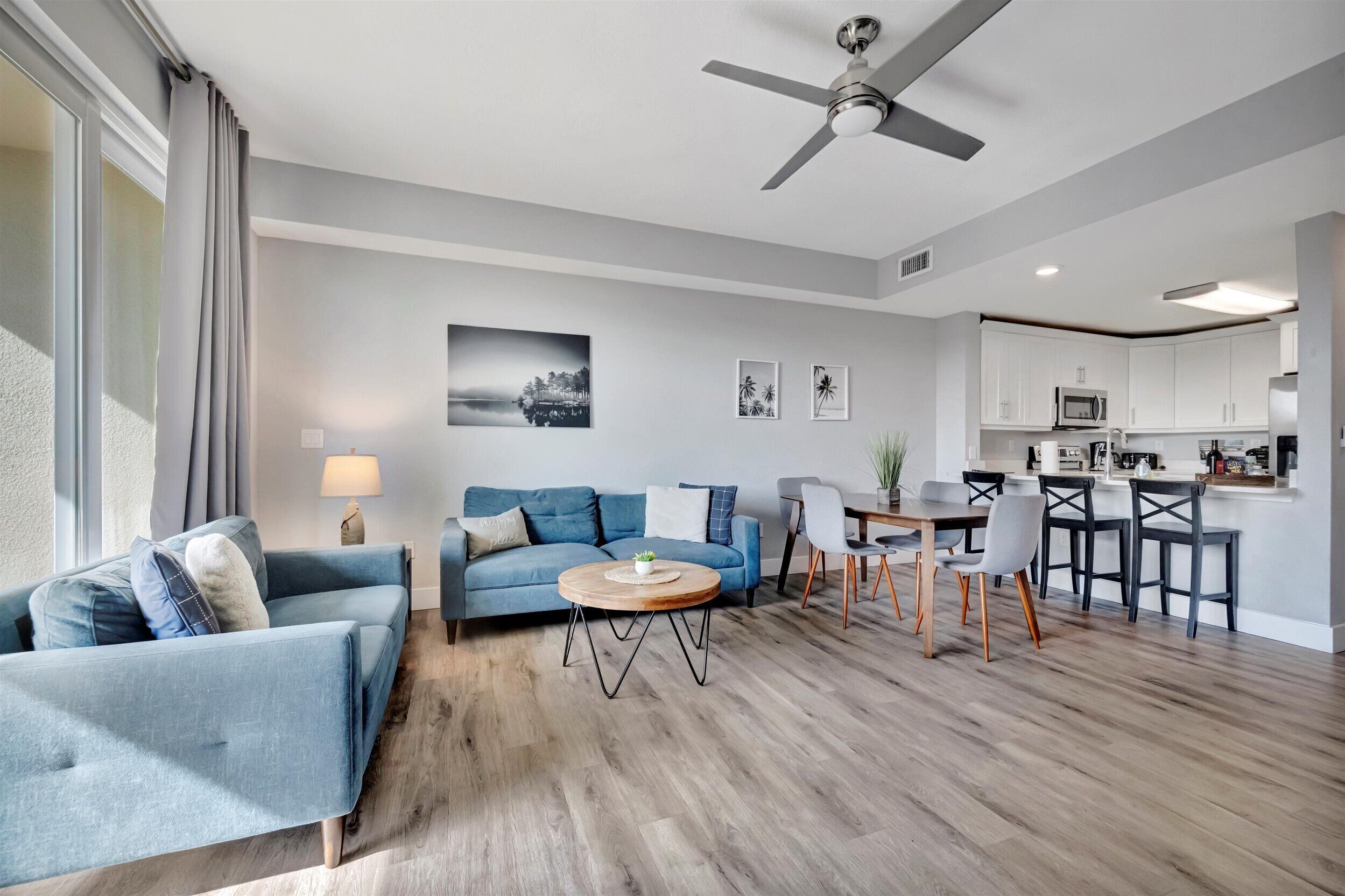 A modern living room with a sofa, coffee table, and dining area.