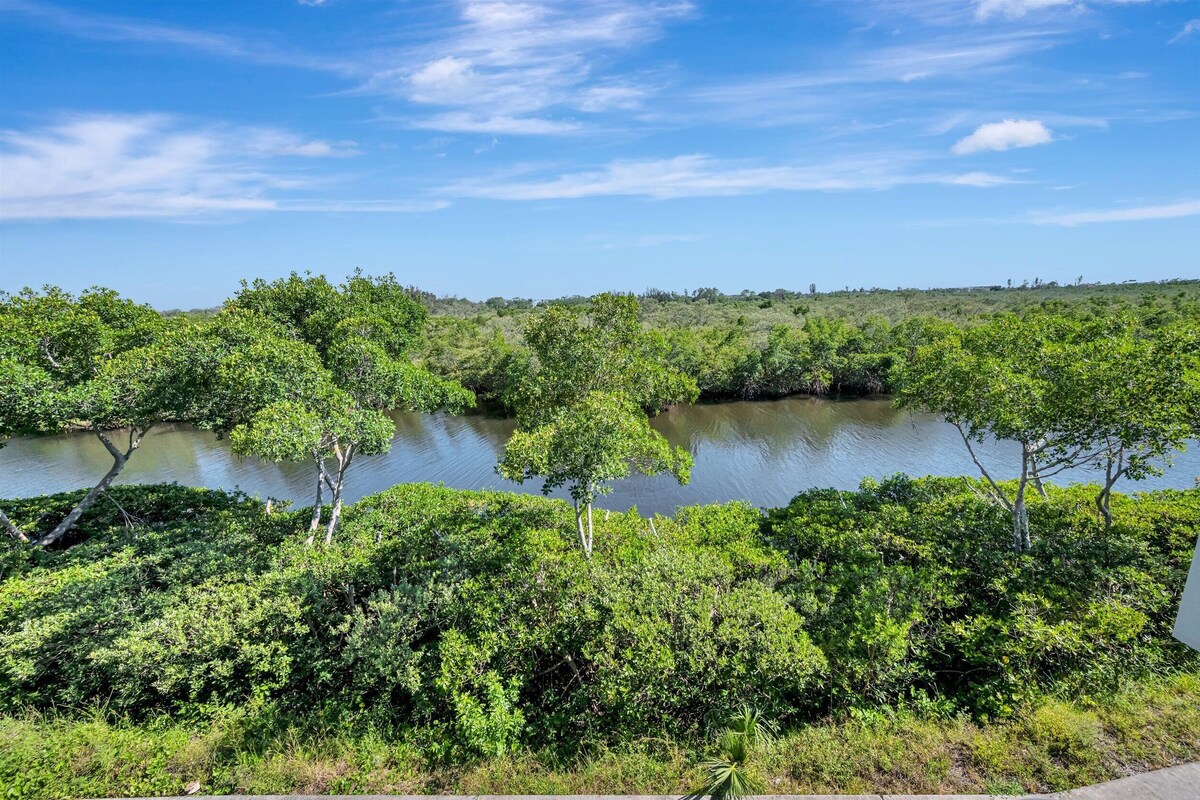 A natural landscape with dense greenery and a body of water.