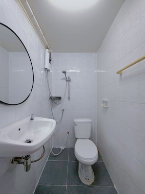 Un baño con lavamanos, inodoro y ducha blancos.
