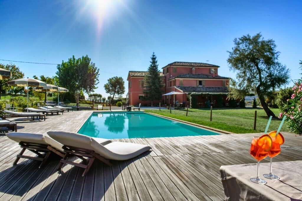 Una piscina al aire libre de temporada, sombrillas, tumbonas