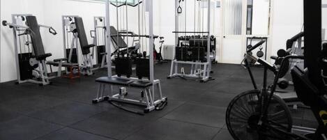 A gym with various exercise equipment, including weight machines and a stationary bike.