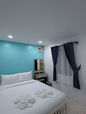 A hotel room with a bed, a nightstand, a mirror, and a window with curtains. - Dream Nest Patong Hotel Patong (Patong)