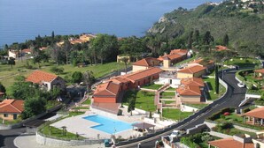A coastal resort with a swimming pool, terraced buildings, and a view of the sea. - Apartment in Cogoleto with pool (Cogoleto)