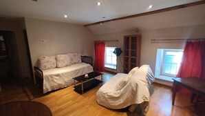 Ein möbliertes Wohnzimmer mit einer Couch, einem Couchtisch und einem Sessel.