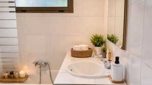 Ein Badezimmer mit einem weißen Waschbecken, einem Spiegel, einem Fenster, einer Toilette und einem grünen Teppich.