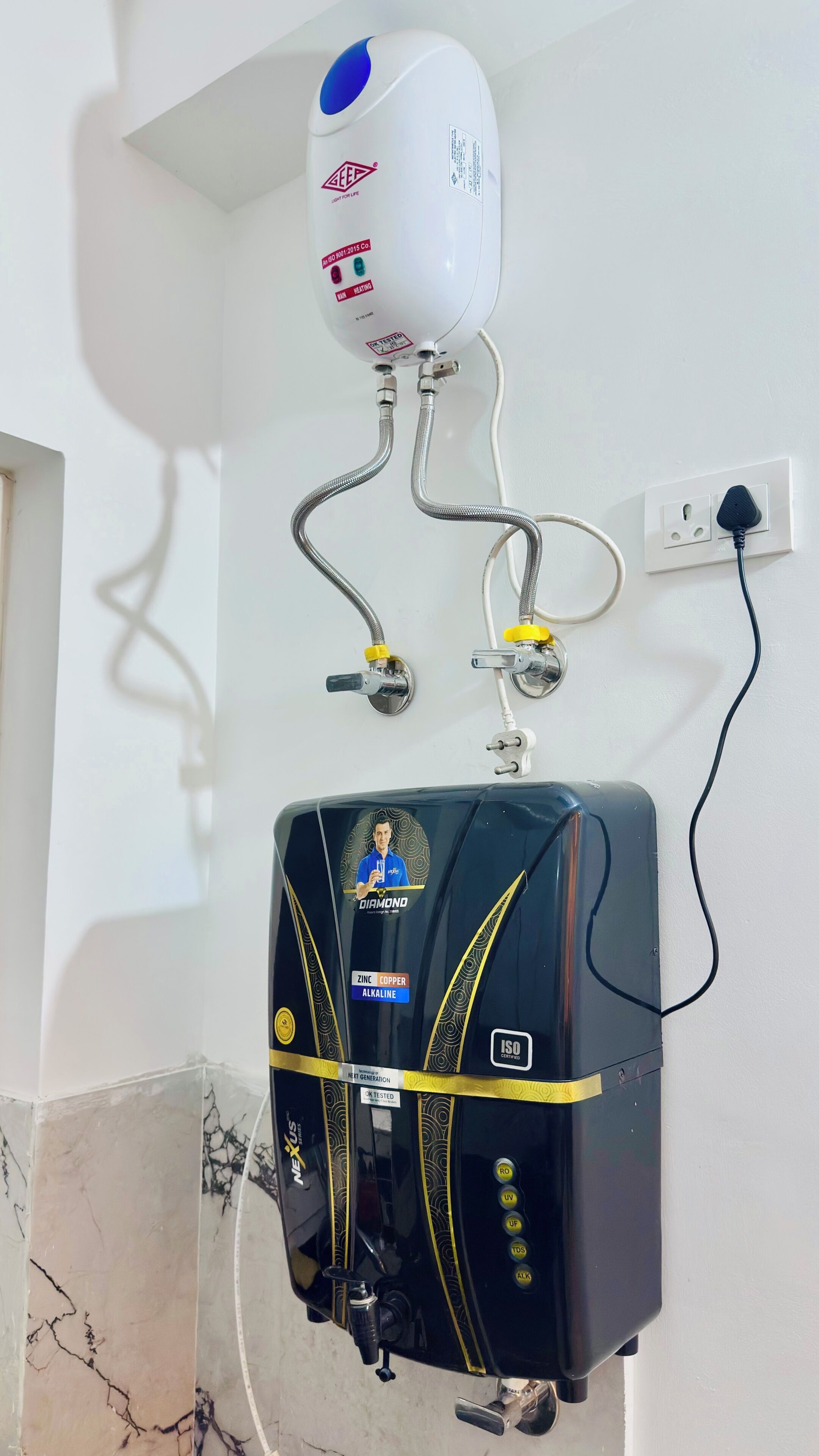 Een waterverwarmer aan de muur bevestigd, met een bedieningspaneel eronder.